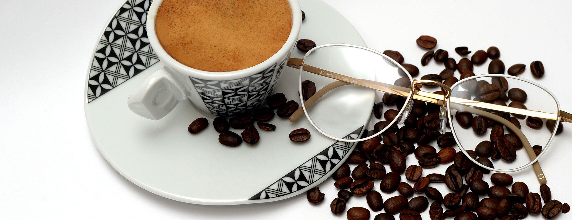 Brille neben Kaffeetasse